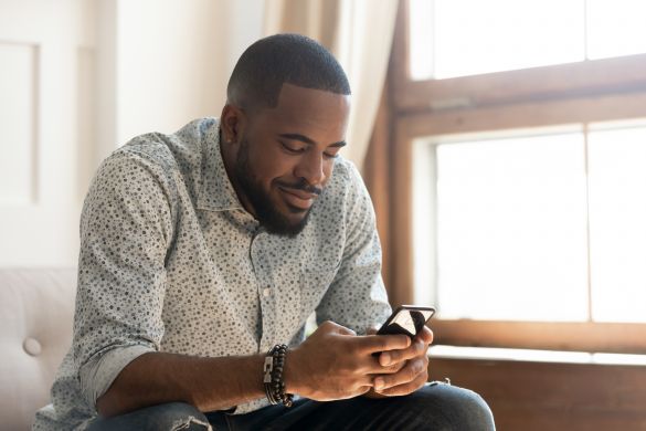 Man sitting on couch looking at mobile