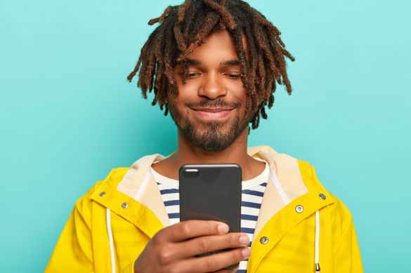 Funky looking young man looking at his mobile phone