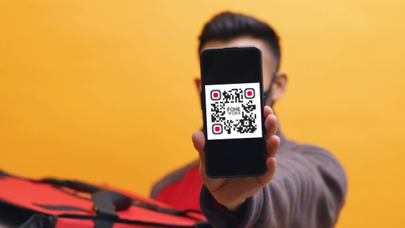 Man holding out cell phone with QR code